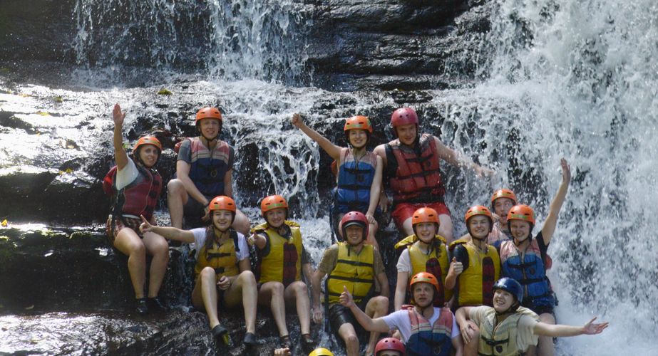 Groepsfoto bij waterval, raften